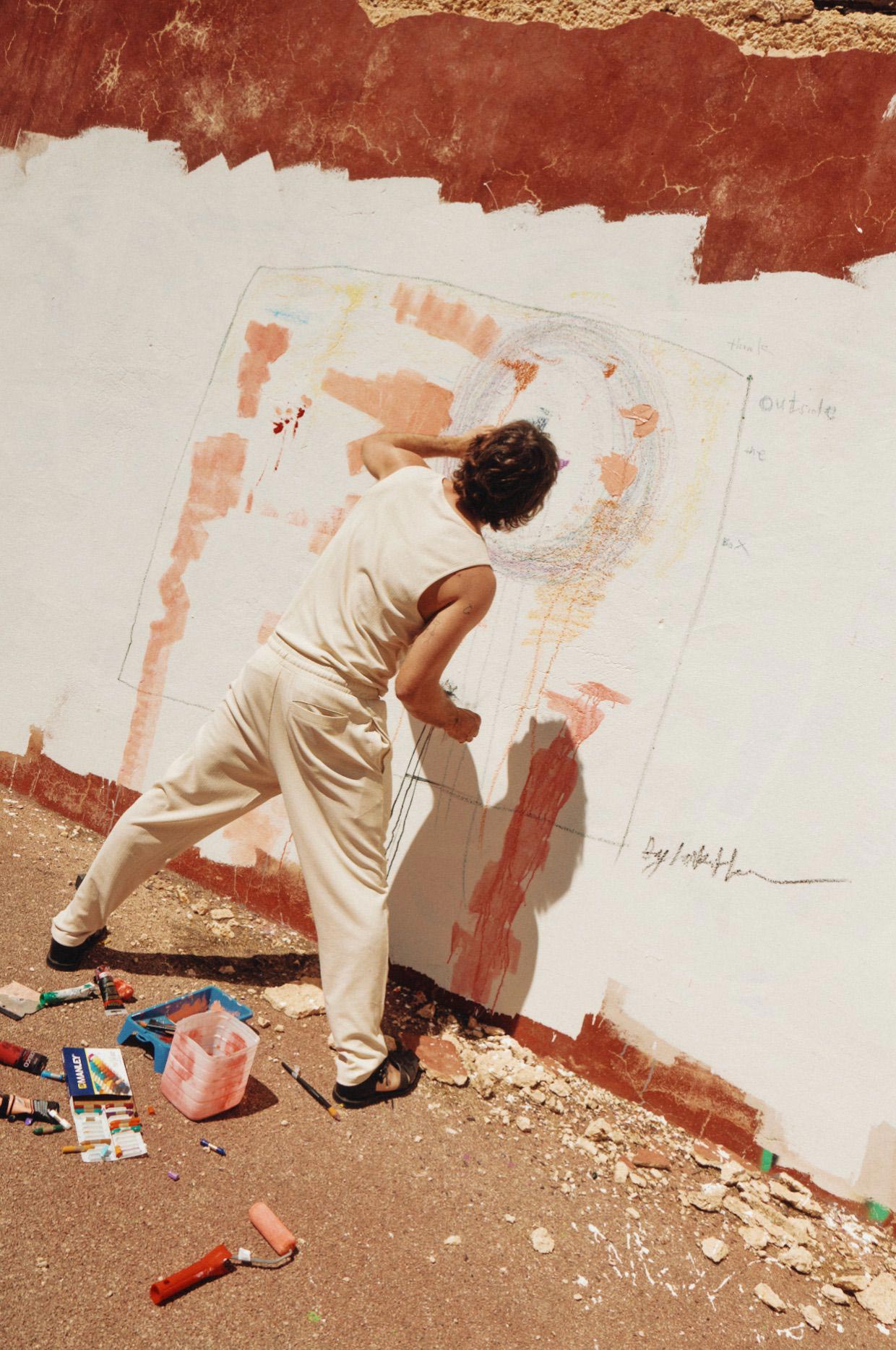 Jake Hall standing up working on a painting