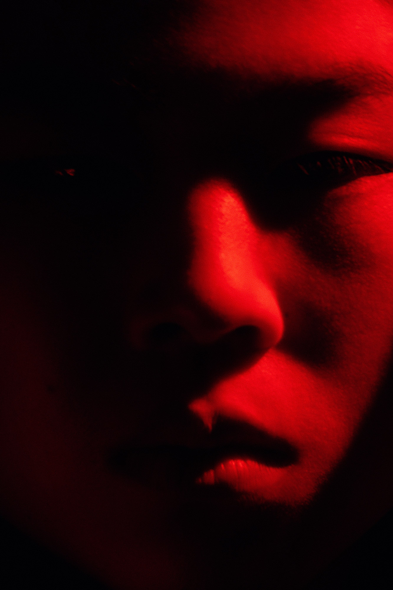 A close up image of a person's face in red light