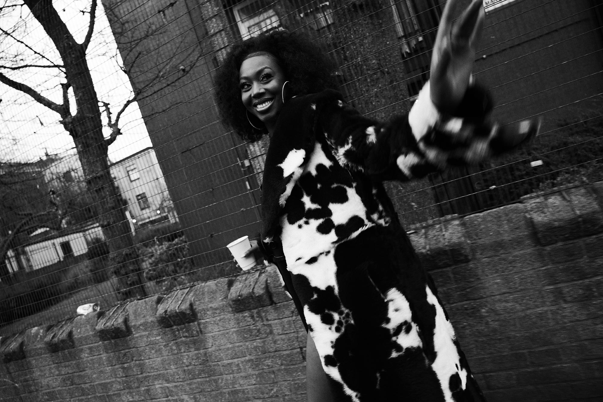 Ms Banks smiles as she walks away from the camera wearing a fur coat