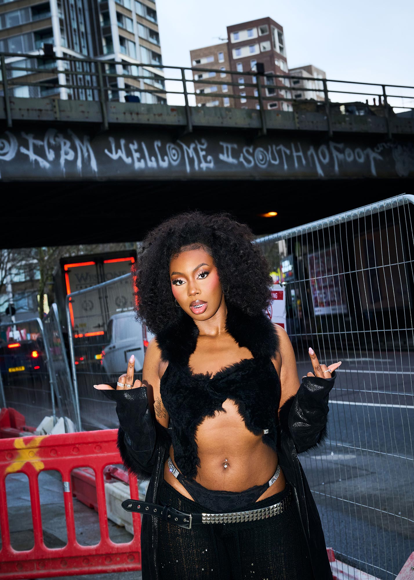 Ms Banks showing two middle fingers in front of some roadworks