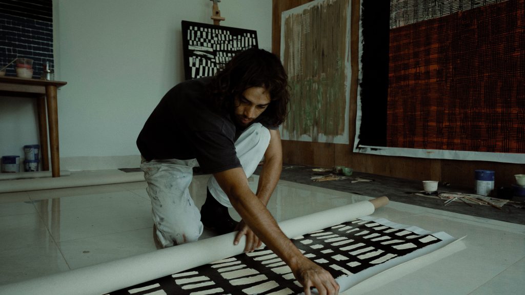 Naleye rolls up a painting