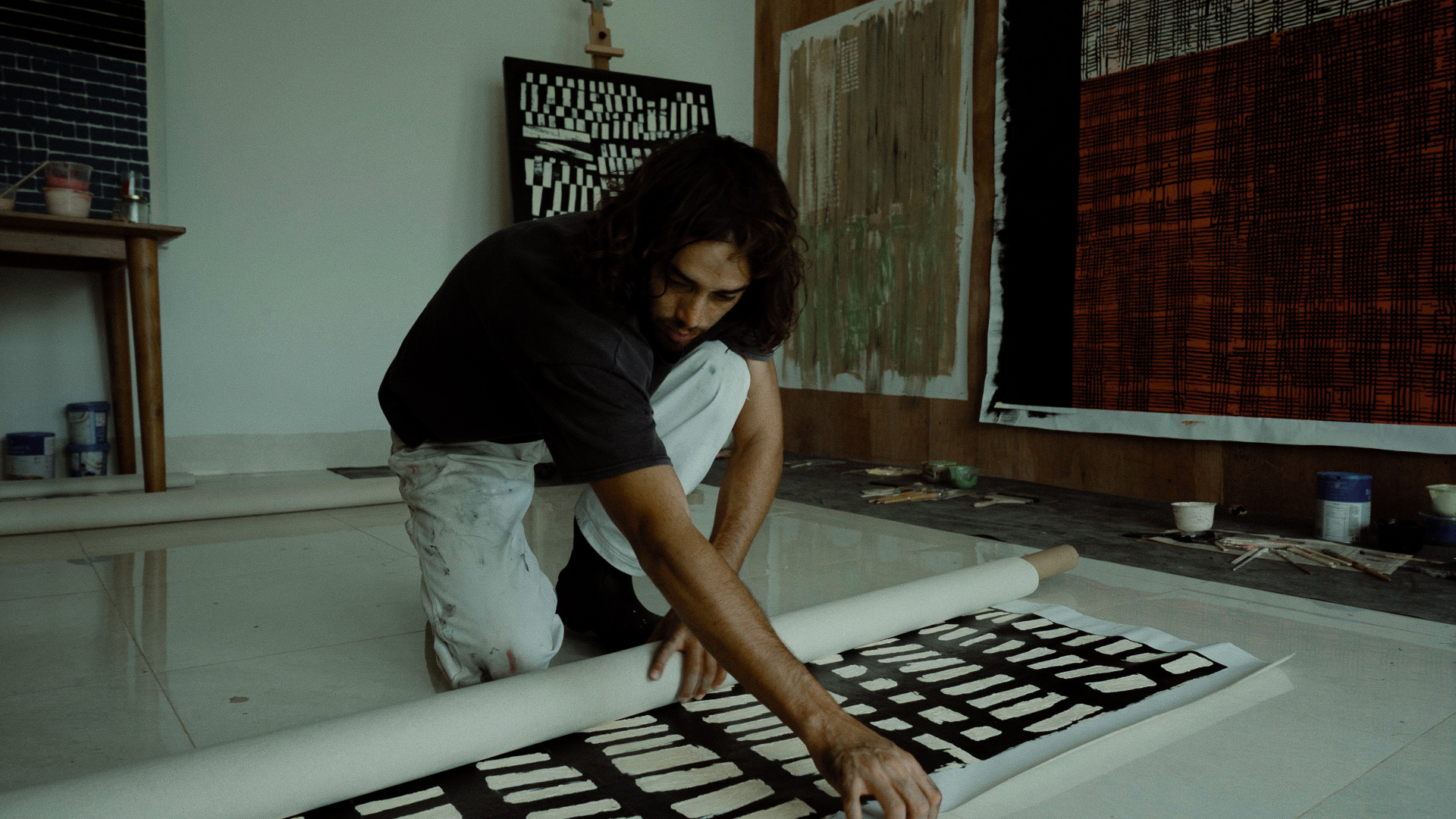 Naleye rolls up a painting