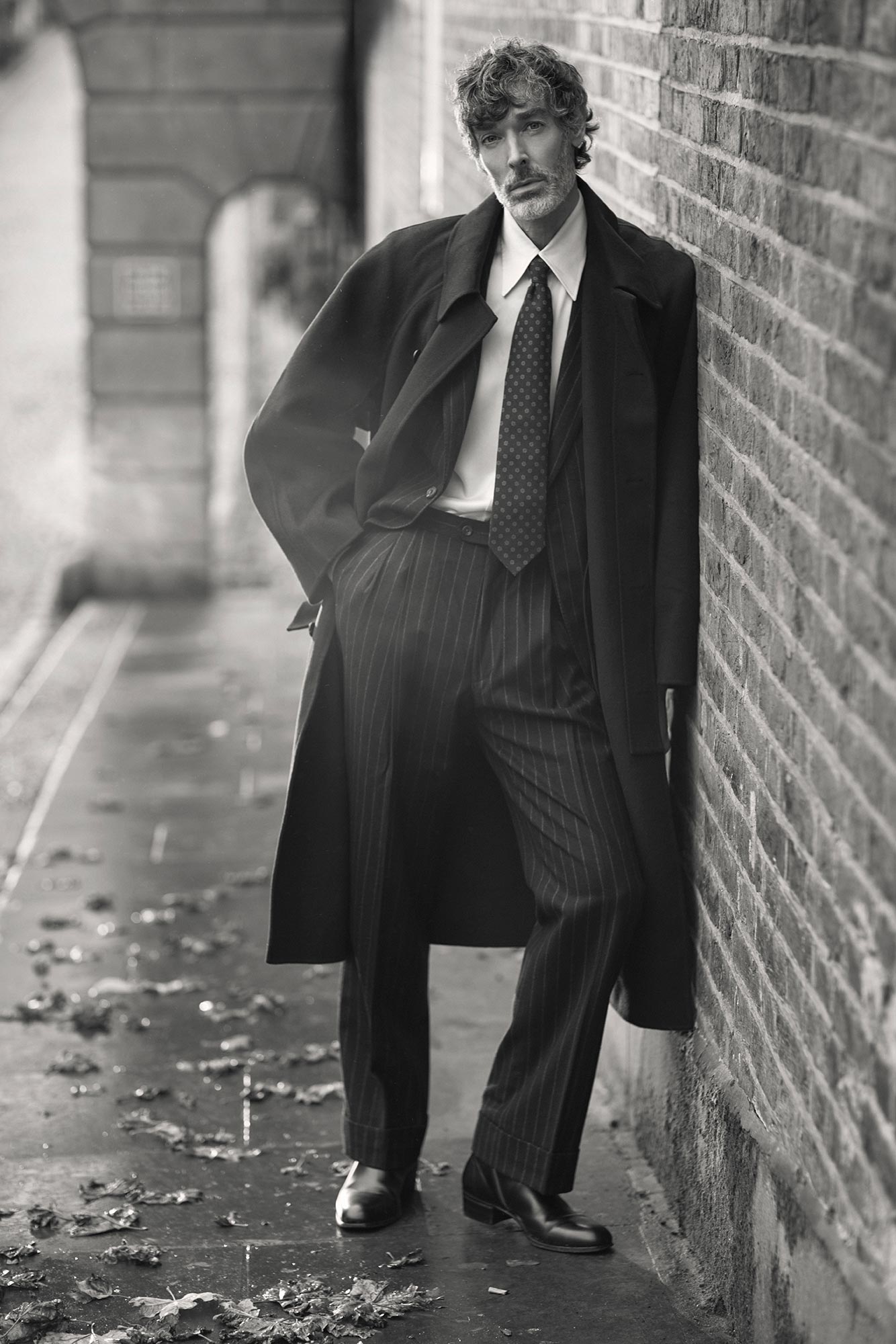 Richard leaning against a brick wall