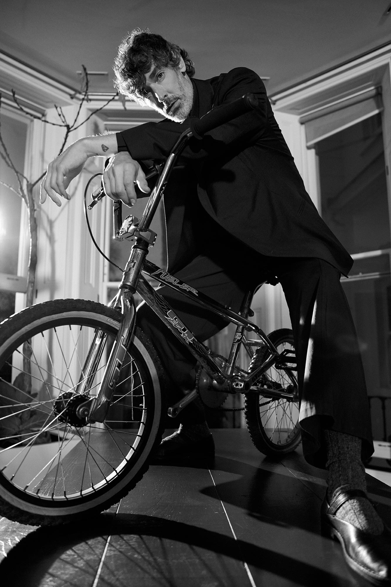 Richard leaning forwards on a BMX bike indoors